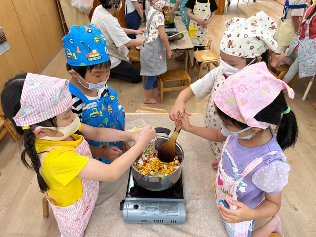 クッキングで鍋をかき混ぜる子どもたち（はっとこども園）