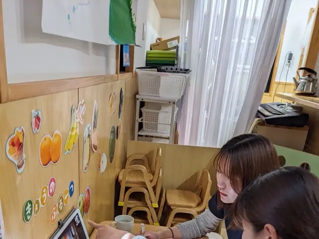 タブレットで打ち合わせる職員(なのは乳児園)